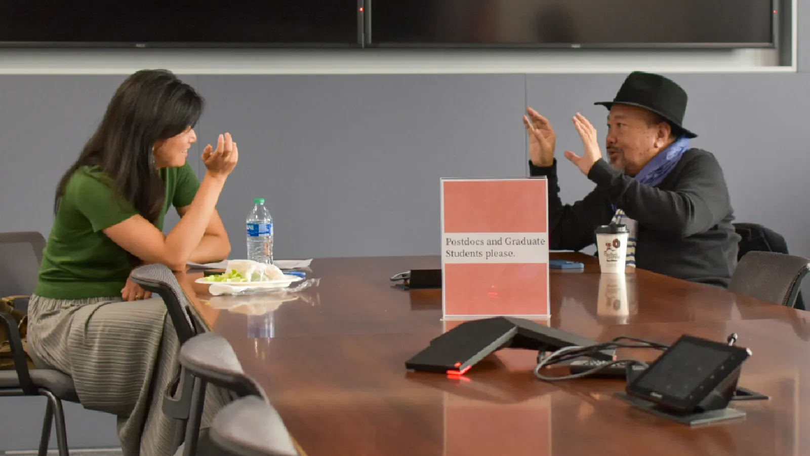 Erin Lin speaks with Rithy Panh while sitting at a table
