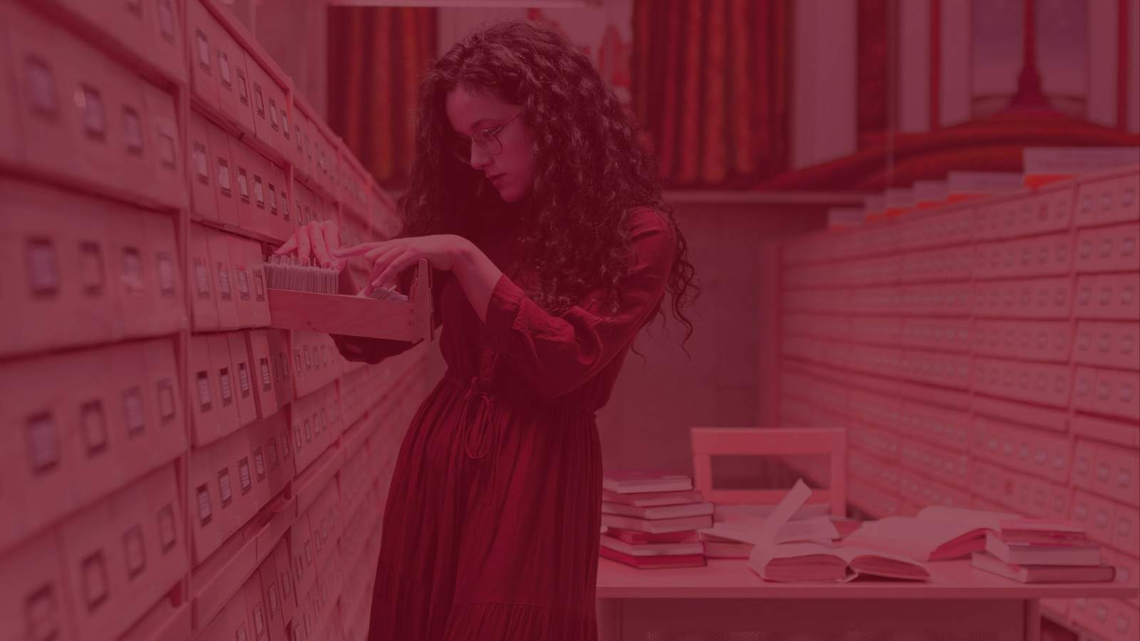 Woman looking in card catalogue in a library 