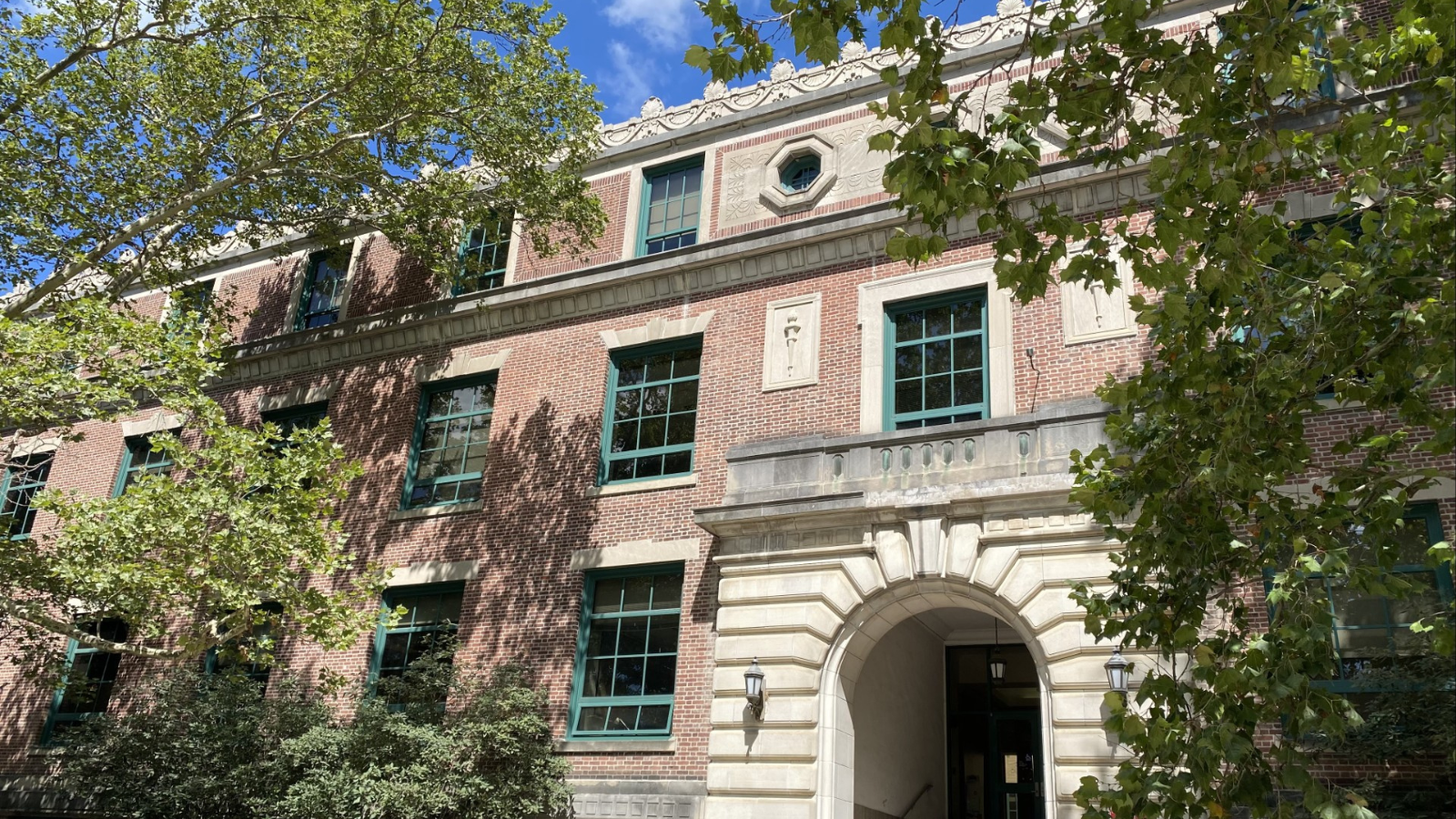 Red brick building with green trim on windows