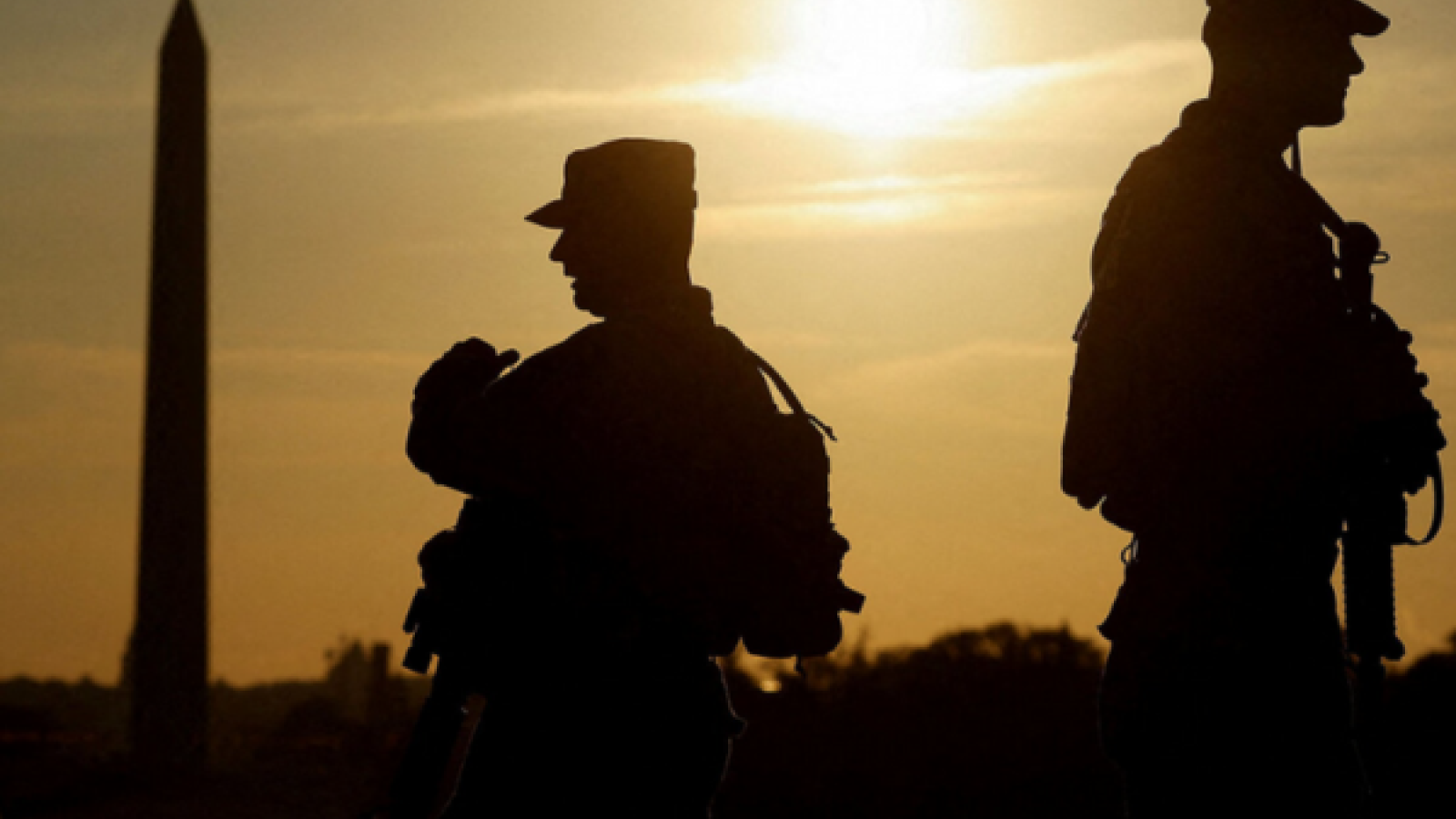 Washington Monument and 2 soldiers at sun down